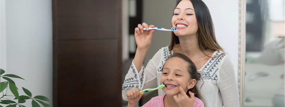Mamá e hija cepillando sus dientes